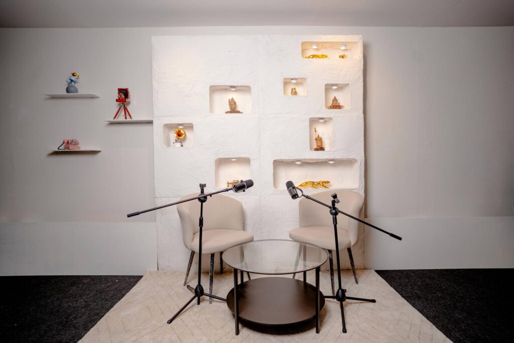 Minimalist podcast recording studio with soft white alcove backdrop and dual mic setup in Mumbai